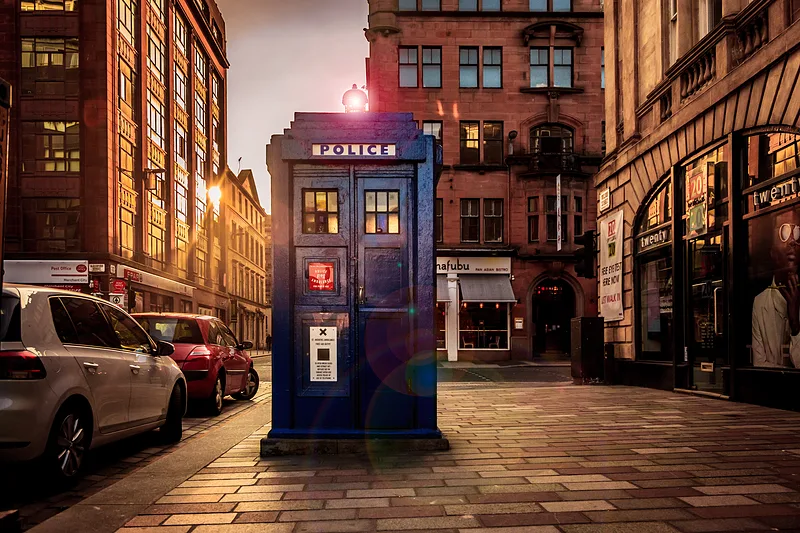 Blaue Police Box in einer Glasgower Straße im warmen Abendlicht.